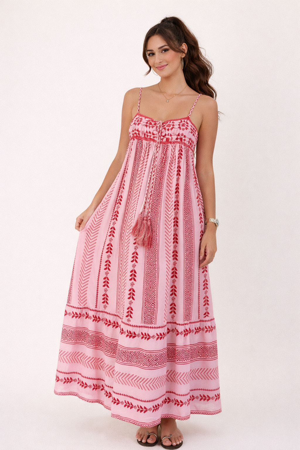 Roze bohemian maxi jurk met patroon en fijne bandjes gedragen door model bij houten deur