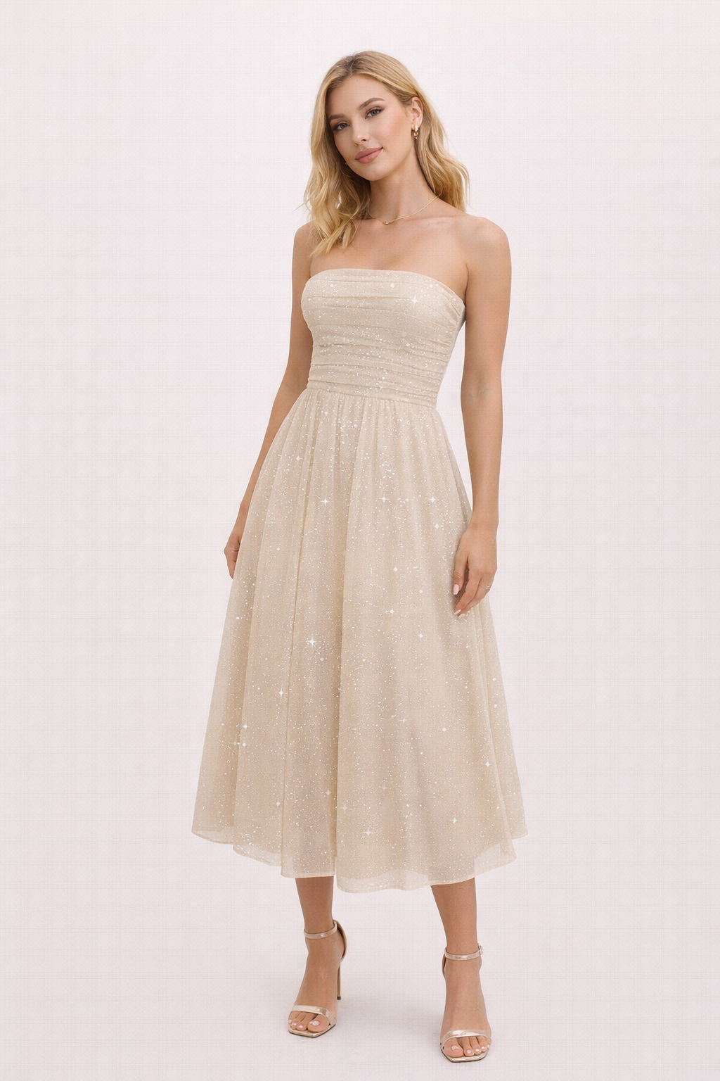 Strapless champagnekleurige avondjurk met subtiele glitter gedragen tijdens een sfeervol diner bij kaarslicht