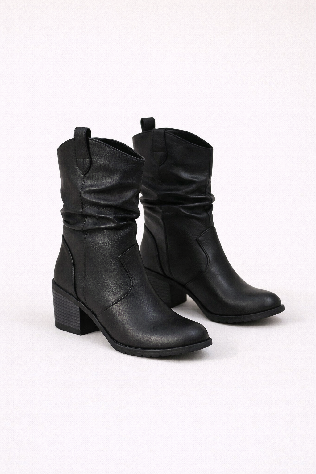 Zwarte slouch enkellaarsjes met hak gedragen door een vrouw, comfortabele damesboots met een casual uitstraling.