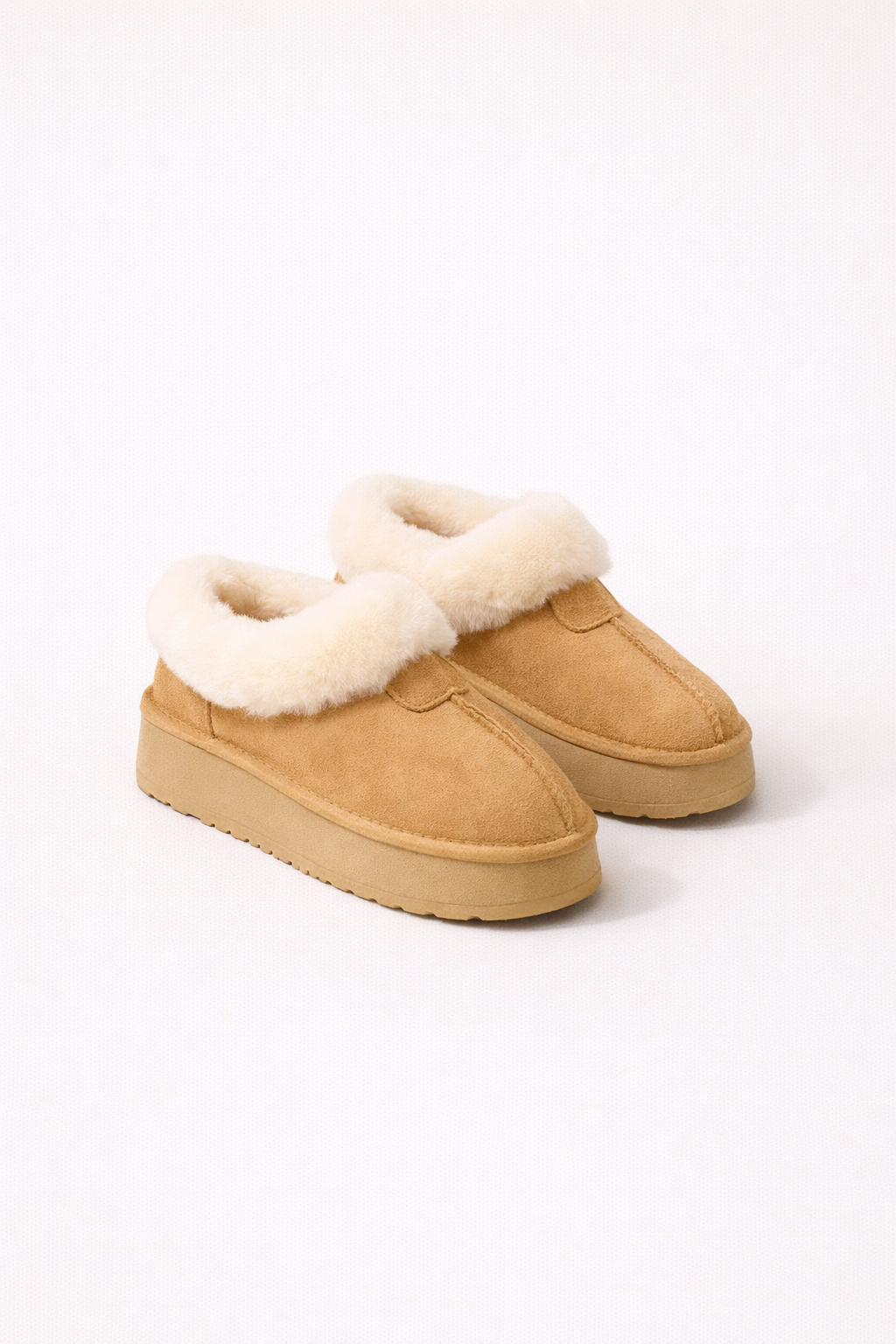Beige winter instappers met zachte witte voering gedragen door een vrouw, warme en comfortabele dames schoenen voor koude dagen.